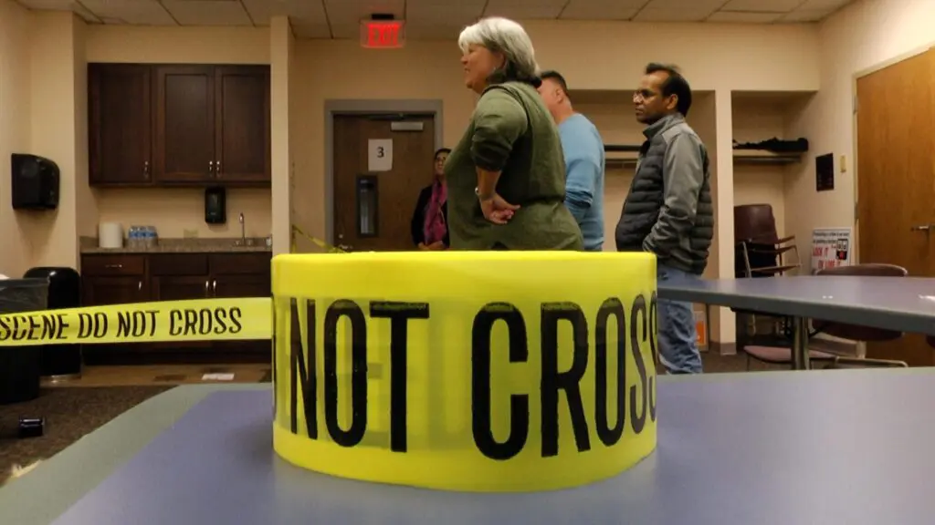 Close up of rolled up crime scene tape in front of participants at Naperville Citizen Police Academy