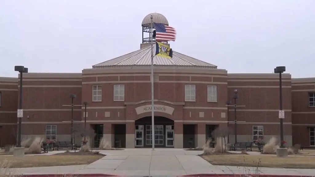 Wide shot of academics building at Neuqua Valley High School with flagpole in front -one of the 204 schools to have work done this summer