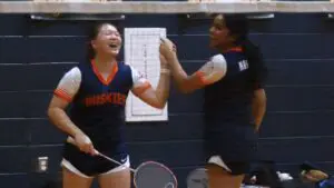 Allison Li celebrates with her teammate Varsha Parthasarathy after a diving point for Naperville North badminton.