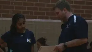 Ishi Reddy and Coach Benson from Neuqua Valley badminton get ready for match against Naperville North