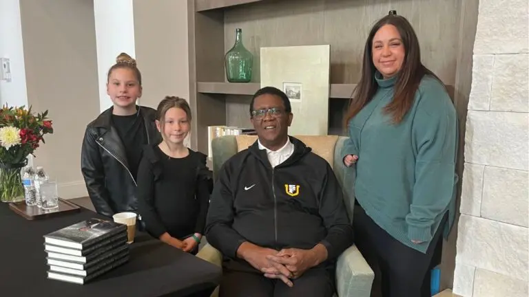 NBA Champion Bill Cartwright takes a picture with three fans at his book signing at Everleigh Naperville.