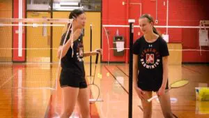 Naperville Central badminton doubles duo Megan Moreno and Zoey Tian talk during game against Waubonsie.