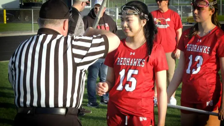 Naperville Central girls lacrosse player Joanne Lee gets her stick checked by the ref.