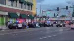 Naperville police officers and three squad cars parked in downtown Naperville night of large gathering