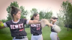Benet softball players throw the ball around before playing Waubonsie Valley.