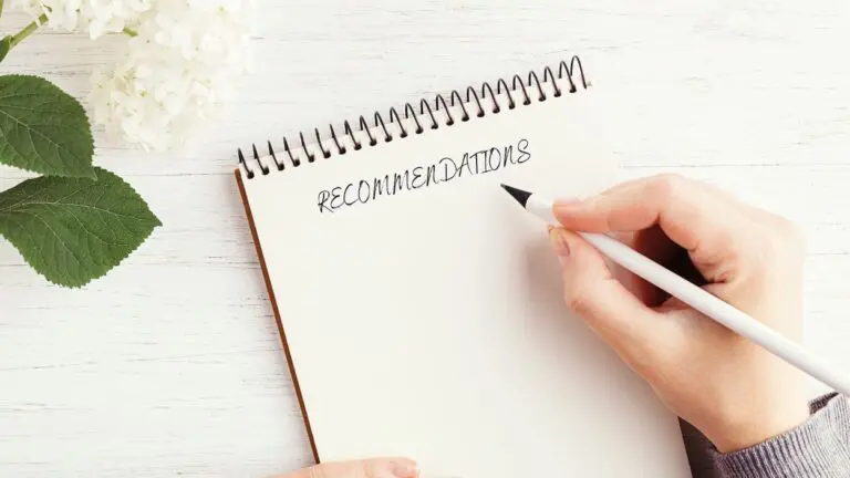 Hand writing word recommendations on notebook with flower in top left of image