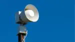 Tornado siren against blue sky