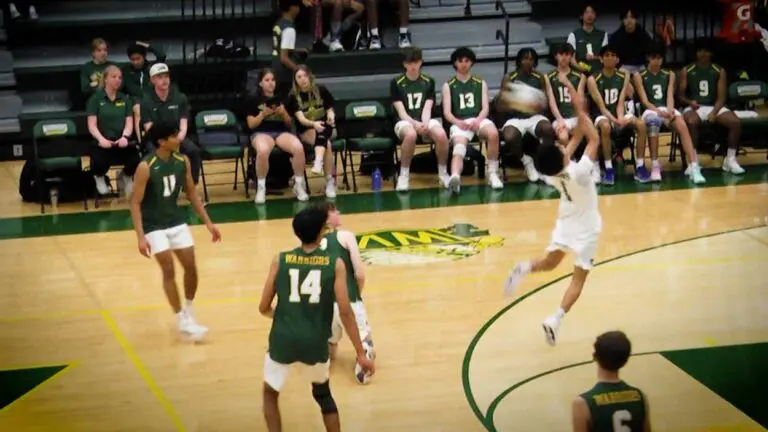 Jonah Aranda hits the ball backwards as The Waubonsie Valley Volleyball team watches.