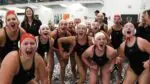 Naperville Central girls water polo flexes to the camera after beating Waubonsie Valley.