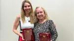 Donna Wandke and Kristin Fitzgerald smile and pose for a picture as they celebrate retiring from the Naperville School District 203 board.