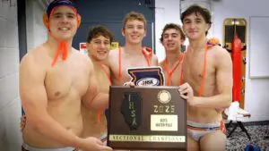 Naperville North boys water polo smiles with the IHSA Boys Water Polo Sectional plaque after beating Waubonsie.