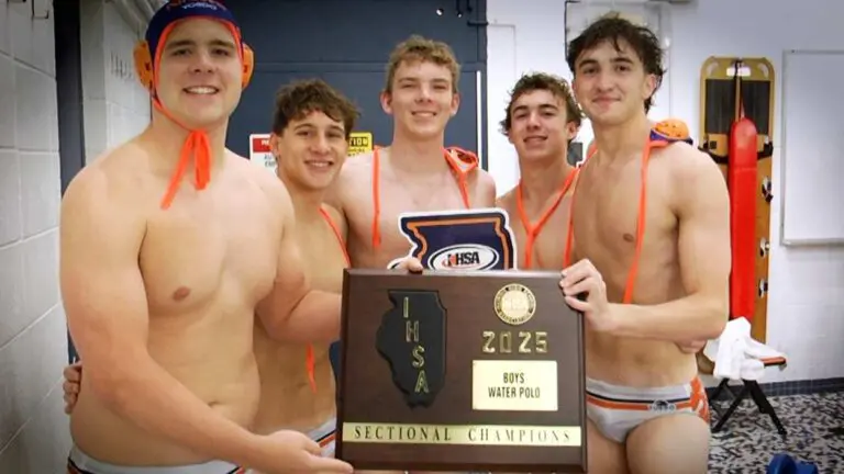 Naperville North boys water polo smiles with the IHSA Boys Water Polo Sectional plaque after beating Waubonsie.