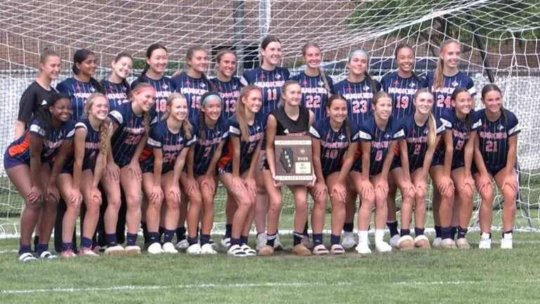 Naperville North Girls Soccer smiles with the Regional plaque after beating Oswego.