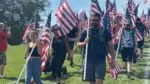 People carry flags down Rotary Hill. Naperville Salute canceled for summer 2025