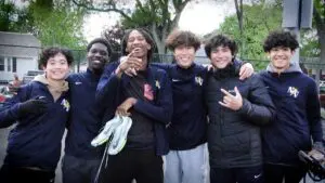 Neuqua Valley boys track and field members smile and post to camera at the IHSA East Aurora Sectional.