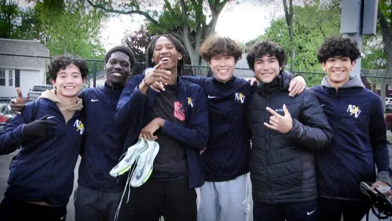 Neuqua Valley boys track and field members smile and post to camera at the IHSA East Aurora Sectional.