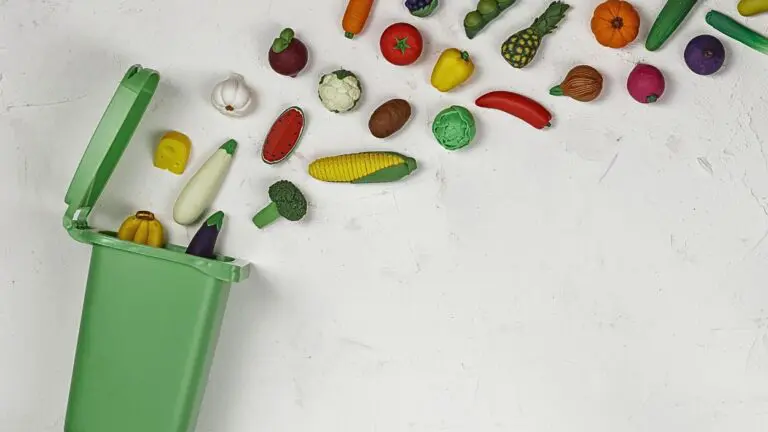 Various pieces of produce flying into a green recycling bin