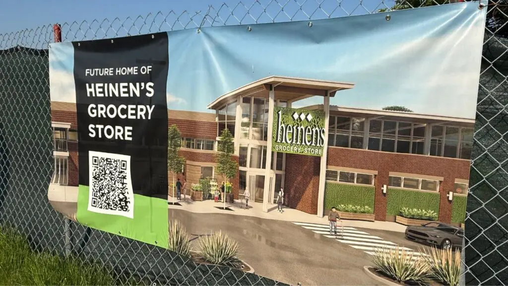 Signage for Heinen's Grocery Store coming soon on chain link fence in Naperville