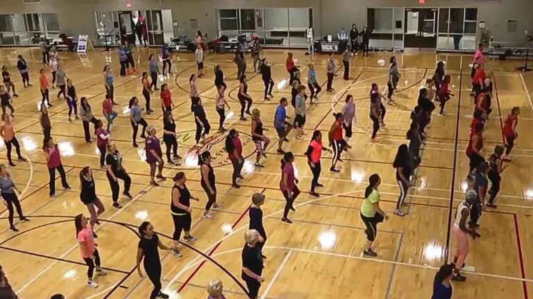 Wide shot of Naperville Park District gym with group of women in lines working out in the indoor space