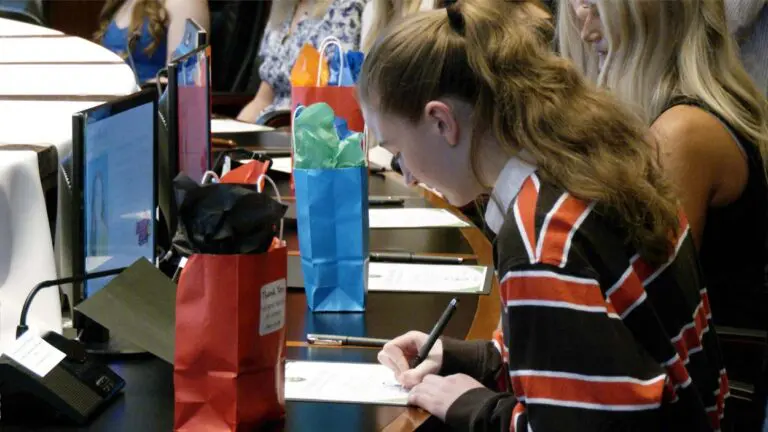 A Naperville high school senior signs a certificate pledging to pursue a career in education
