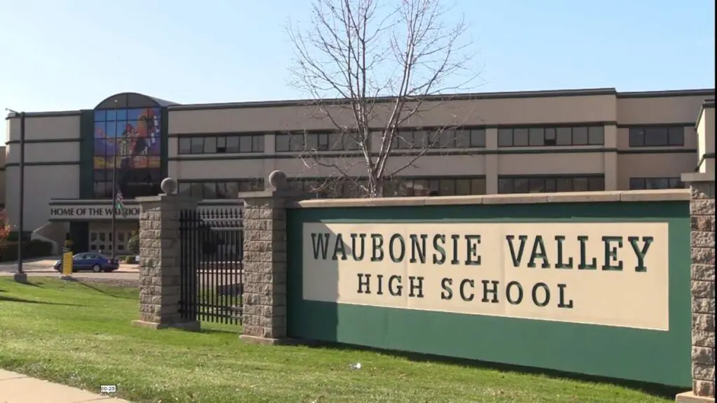 Exterior shot of Waubonsie Valley High School sign with high school building behind it