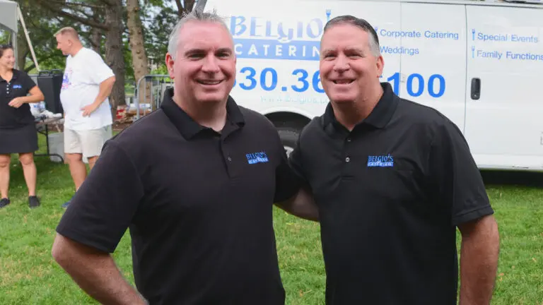 Brothers Tim and Tom Belgio pose in Belgio's Catering polos in front of their company truck.