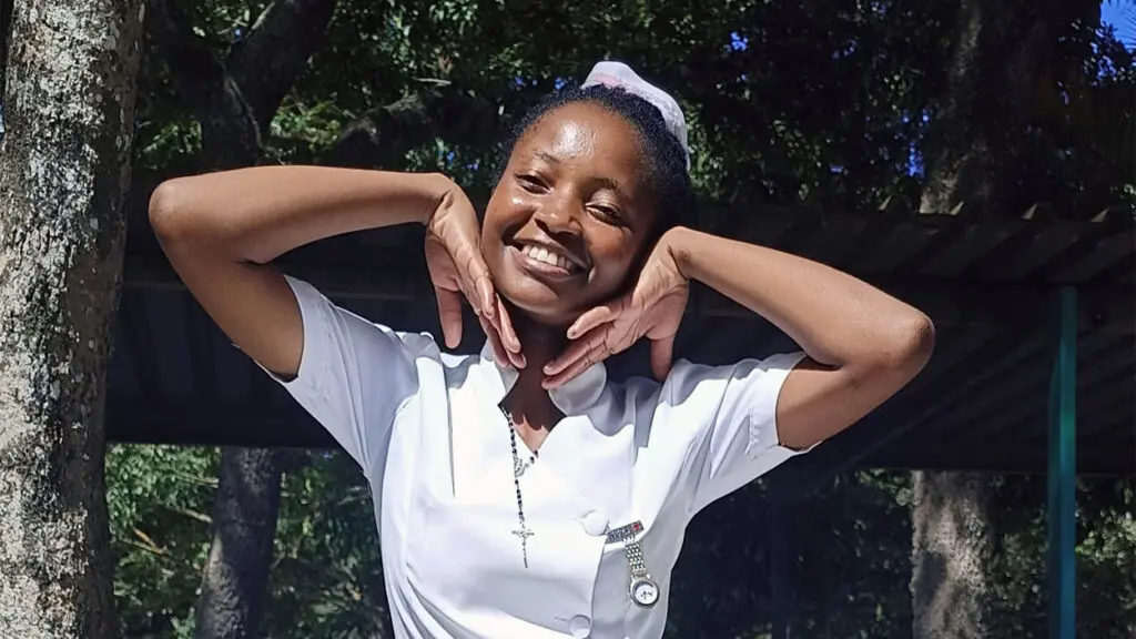 A young woman in a white nursing uniform.