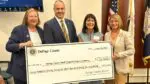 DuPage County Board Human Services Committee Vice-Chair Paula Deacon Garcia, DuPage County Board Human Services Committee Chairman Greg Schwarze, Lynn Dugan, Director of Repeat Boutique and DuPage County Board Chair Deborah Conroy holding giant check for grants to be presented to local nonprofits