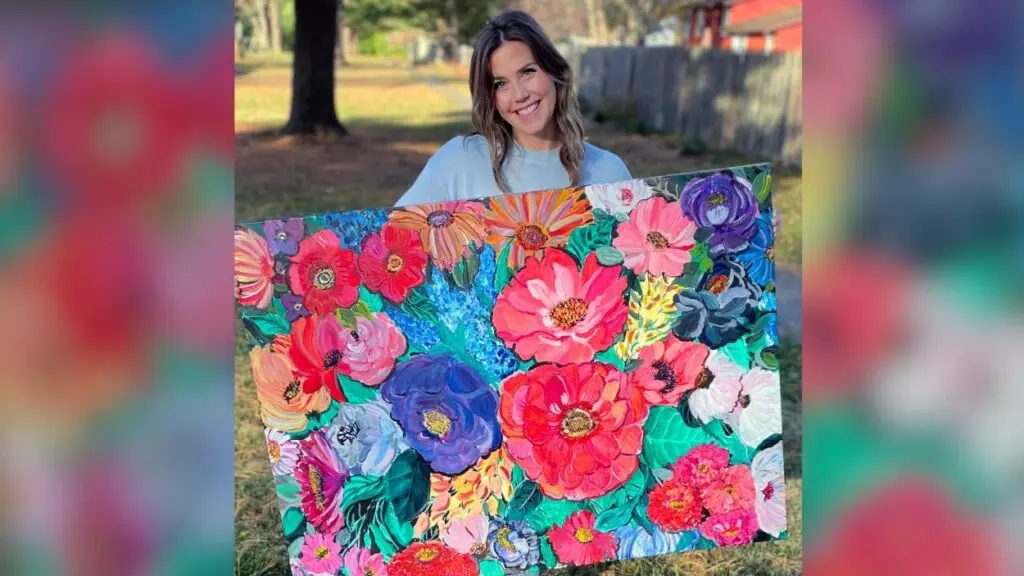 Artist Lindsay Jones holding up her painting Hope Replaced Fear