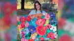 Artist Lindsay Jones holding up her painting Hope Replaced Fear