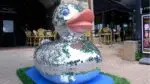 A new shiny disco duck sculpture sits in front of a local business in downtown Naperville, one of the many giant duck sculptures in town.