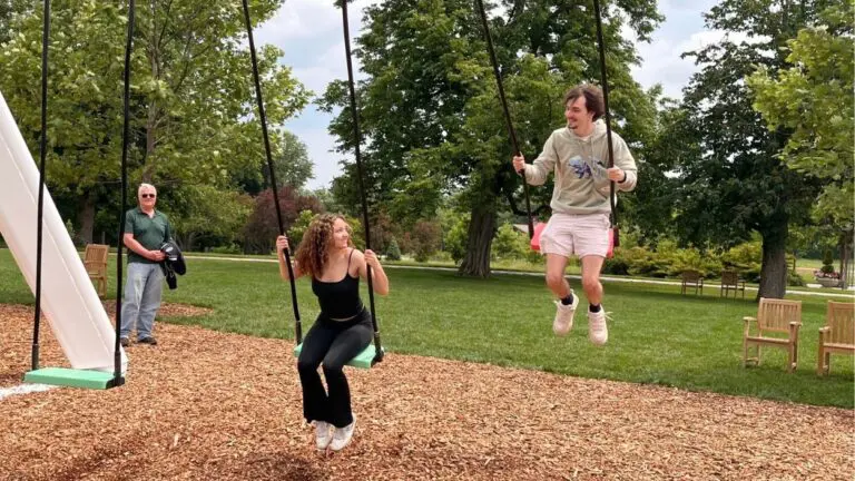 A young couple uses the musical swings at Cantigny Park while a man looks on. The swings are a part of the "Feast of the Senses."