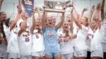 Naperville North girls soccer smiles and cheers with the SuperSectional plaque after beating Wheaton Warrenville South.