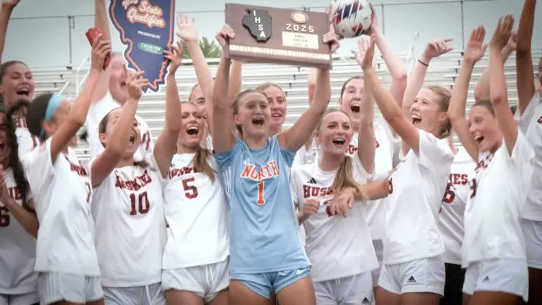 Naperville North girls soccer smiles and cheers with the SuperSectional plaque after beating Wheaton Warrenville South.