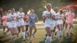 Naperville North girls soccer team smiles and runs to thank the fans after beating Lane Tech in the IHSA State Semifinals.