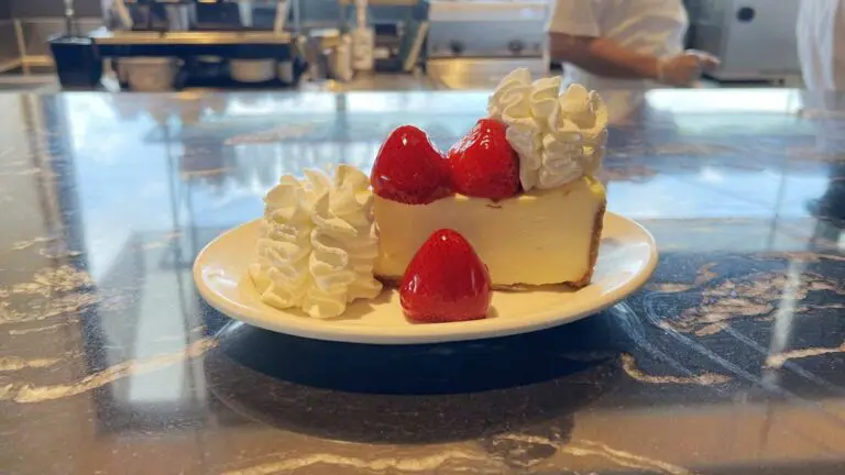 A cheesecake slice with strawberries and whipped cream