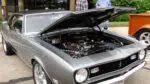 Classic silver car with hood open at vintage car show in downtown Naperville