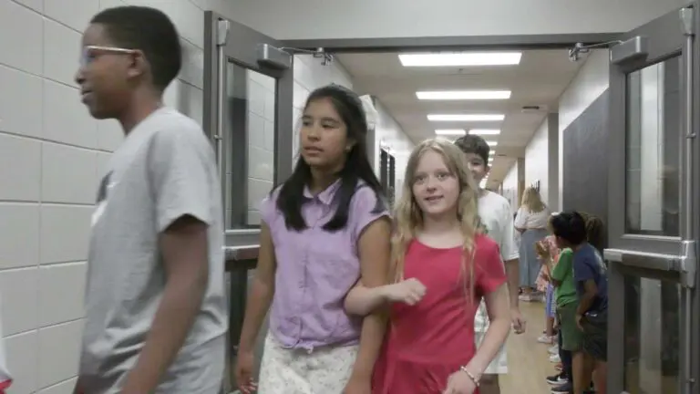 Three students walking during the clap out