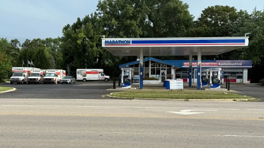 Wide shot of Marathon gas station with UHaul trucks on site