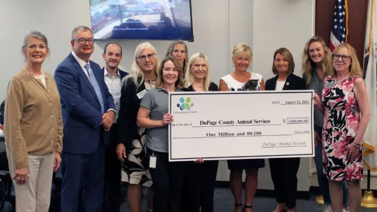 Group of people standing holding a giant check to the DuPage County Animal Services for 1 million dollars.