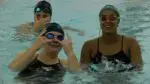 Waubonsie Valley girls swimmers smiling before match against Metea Valley