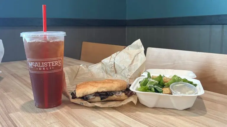 A photo of an iced tea, sandwich, and salad from McAlister's Deli