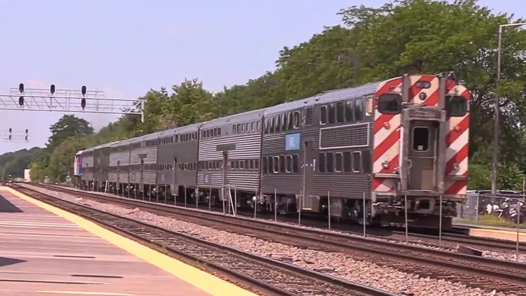 Wide shot of Metra train on track going through Naperville