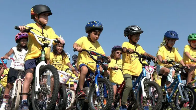 Kids in yellow shirts lined up on bikes at starting line of Junior Tour de Naperville