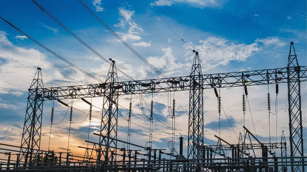 sunrise behind electric substation towers