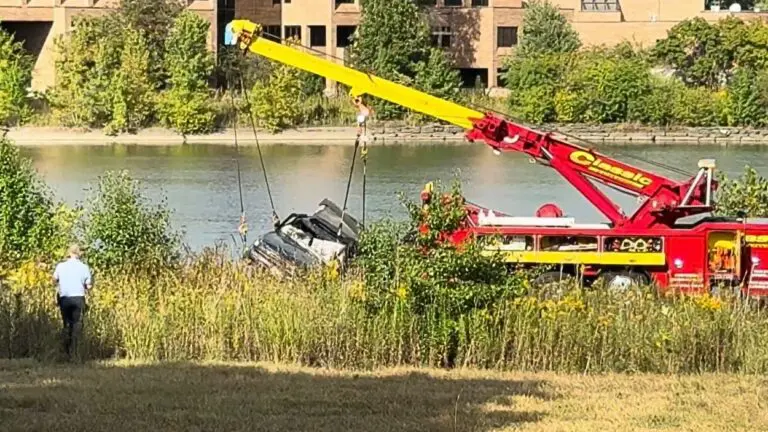 Car being pulled from Lake Osborne by crane tow truck
