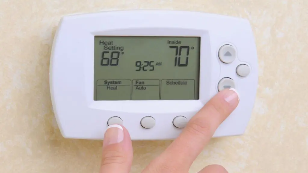 Stock photo of someone adjusting a thermostat