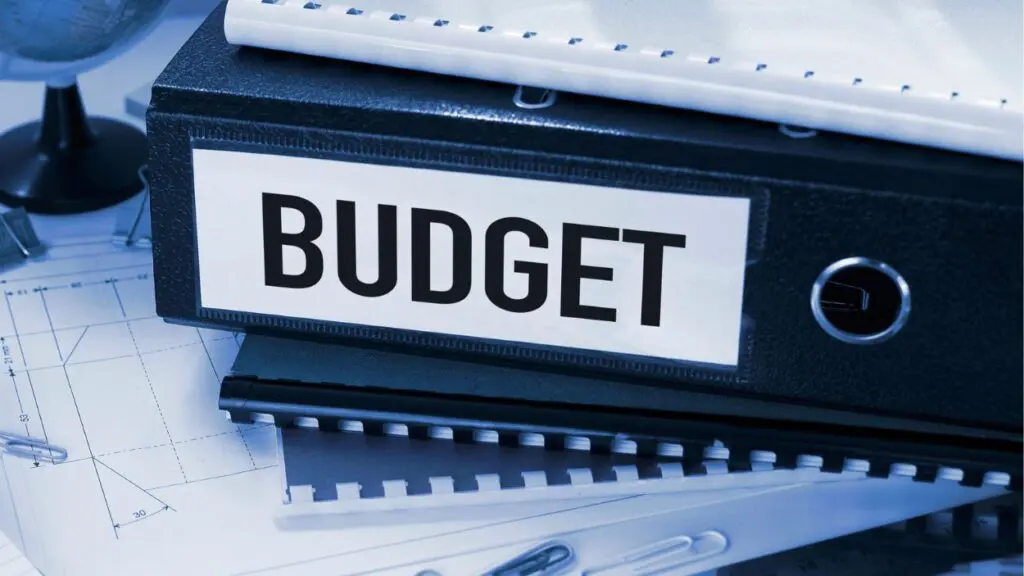Stack of notebooks and binders with the word budget written on the spine of one binder