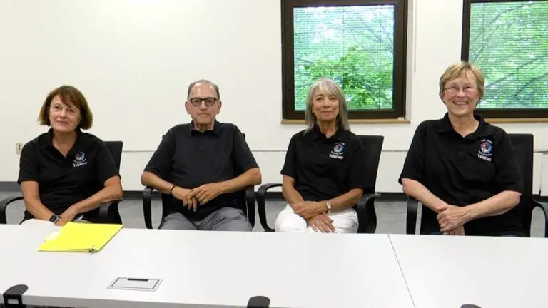 The four tour guides of the Naperville Police Department smile for a picture.