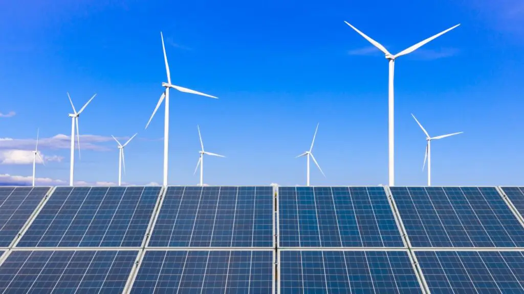 Solar panels and wind turbines against a blue sky